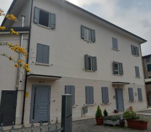 a white building with gray doors and windows at Apartment Andromeda in Reggio Emilia