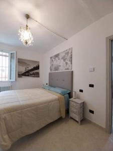 a white bedroom with a bed and a chandelier at Apartment Andromeda in Reggio Emilia