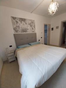 a large white bed in a room with a chandelier at Apartment Andromeda in Reggio Emilia