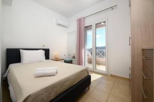 a bedroom with a bed and a large window at Sea View Home - Rena's House in Corfu Town