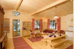a living room with a table and a kitchen at Loikansaari Lomamökit Holiday Cottages in Savonlinna