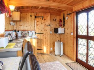 uma cozinha com paredes de madeira e pisos de madeira num camarote em Packhorse Shepherds Hut em Belper