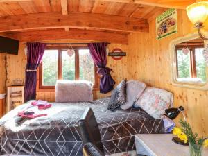 um quarto com uma cama num chalé de madeira em Packhorse Shepherds Hut em Belper