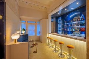 un bar con taburetes naranjas en una habitación en The Capital Boutique Hotel en La Valeta