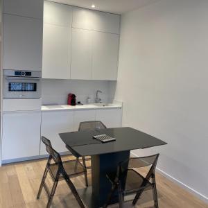 a kitchen with a black table and two chairs at CROISETTE VUE MER LATERALE in Cannes