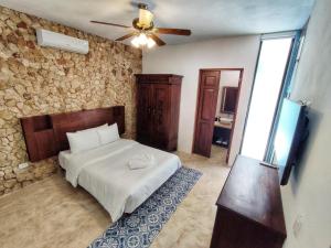 um quarto com uma cama e uma ventoinha de tecto em Boutique Casa Azuli Santiago em Mérida