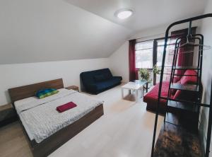 1 dormitorio con 1 cama y 1 sofá azul en K-Town - Apartment near the Lake, en Kaunas