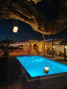 una piscina por la noche con luces en Casasalento, en Cavallino di Lecce