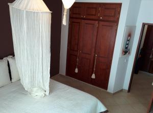 a bedroom with a bed with a white canopy at Erike Guest House in Carvoeiro