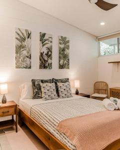 a bedroom with a bed with two paintings on the wall at BoHo Home in Gated Eco Residence marAmar - Top location in Santa Teresa Beach