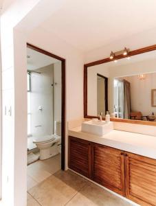 a bathroom with a sink and a toilet and a mirror at BoHo Home in Gated Eco Residence marAmar - Top location in Santa Teresa Beach