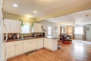 a kitchen with white cabinets and a hard wood floor at Pierre Vacation Rental with Grill and Fenced Yard in Pierre