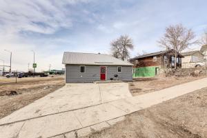 a small house with a red door on a dirt road at Pierre Vacation Rental with Grill and Fenced Yard in Pierre