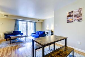 a living room with a blue couch and a table at Raleigh Condo Near Campus and Museums! in Raleigh