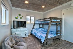 a bedroom with a bunk bed and a tv at Gold Beach Home with Hot Tub, quarter Mi to Beach! in Gold Beach