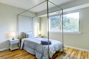 a bedroom with a canopy bed and a window at Raleigh Condo Near Campus and Museums! in Raleigh
