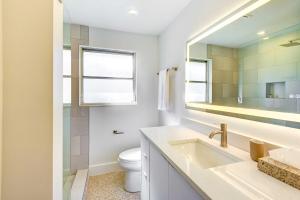 a bathroom with a sink and a toilet and a mirror at Charming Sarasota Vacation Home Near Downtown in Sarasota +19 photos