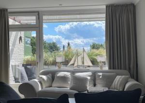 a living room with a couch and a large window at Ostsee Küstenliebe Grömitz in Grömitz