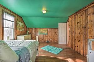 a bedroom with wooden walls and a bed with a green ceiling at Rural Oswego Cottage on 50-Acre Orchard and Farm! in Oswego
