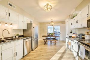 cocina con armarios blancos y suelo de madera en Spacious Columbia Vacation Rental Near Mizzou en Columbia