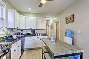 a kitchen with white cabinets and a wooden table at Jersey City Apartment Near Liberty State Park in Jersey City