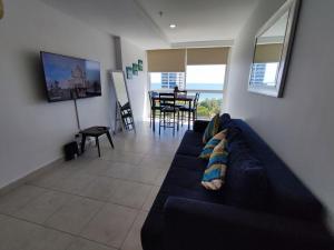 a living room with a blue couch and a table at Apartamentos en Playa Coronado in Playa Coronado