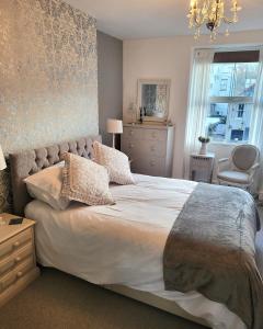 a bedroom with a large bed with a chandelier at Willesden, Flat1 Lovely Spacious 1 Bedroom Flat, heart of Llandudno in Llandudno