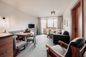 uma sala de estar com uma mesa e cadeiras e um sofá em Alpenappartements Cristall em Ehrwald