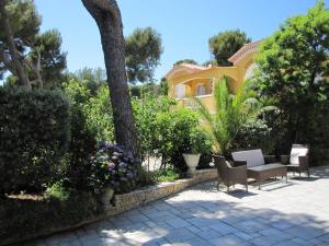 a yellow house with chairs and a table and flowers at Studio dans villa de charme, piscine, proche plage in Cassis +19 photos