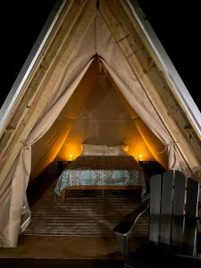 een slaapkamer in een tent met een bed erin bij Bohamia - Cozy A-Frame Glamp on 268 acre forest retreat in Talladega