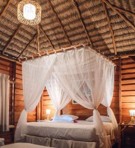 um quarto com uma cama com rede mosquiteira branca em Pousada BGK em Barra Grande