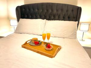 a tray with two glasses of orange juice and strawberries on a bed at Sleeps 10-12 Snowdonia North Wales Nr Zip World in Tanygrisiau