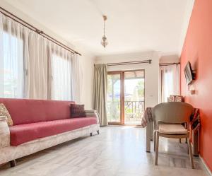 sala de estar con sofá rojo y silla en Loya Vita Hotel, en Dalyan