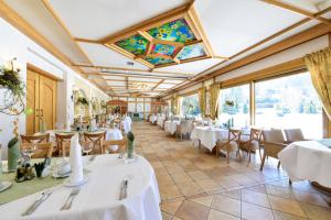 a restaurant with white tables and chairs and windows at SPA Hotel Jawor in Jaworze