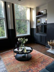 a living room with a table and two windows at Luxury Apartment in the heart of Newcastle centre in Newcastle upon Tyne