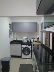 a white kitchen with a washing machine in it at De lucca home Studio in Florianópolis