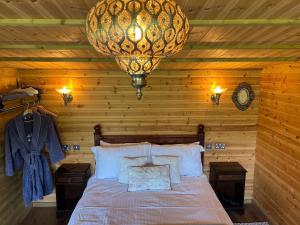 a bedroom with a bed and a chandelier at Silver Springs Farm Lodge in Dingestow