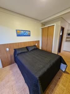um quarto com uma cama com um edredão azul em Condomínio Paraíso do Rosa em Imbituba