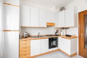 a kitchen with white cabinets and a sink at Residence Fragole Apartment Venice in Campalto