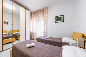a hotel room with two beds and a mirror at Residence Fragole Apartment Venice in Campalto
