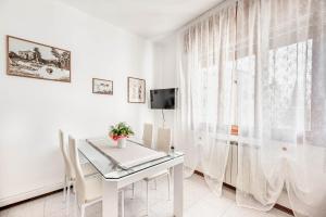 a white dining room with a white table and a window at Residence Fragole Apartment Venice in Campalto