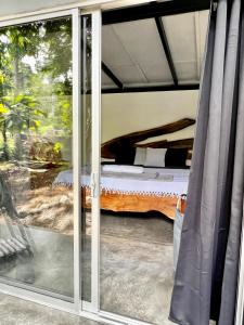 a sliding glass door with a bed in a room at Whispering Wisdom in Cahuita