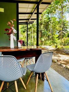 a table with two chairs and a vase of flowers at Whispering Wisdom in Cahuita
