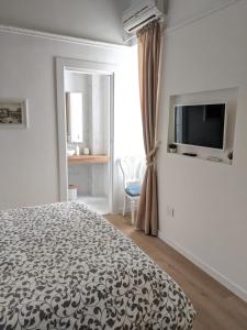 een slaapkamer met een bed en een flatscreen-tv bij San Carlo Apartment in Napels