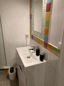 biała łazienka z umywalką i lustrem w obiekcie Appartement T1 Avignon centre w Awinionie