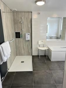 uma casa de banho com um chuveiro e um lavatório. em Shelleven Guest House em Bangor