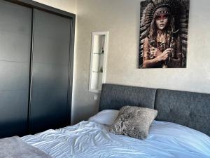 a bedroom with a bed with a picture on the wall at Appartement front de mer avec piscine en face des plages privées in Dar Bouazza +16 photos