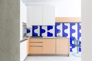eine Küche mit weißen Schränken und blauen und weißen Fliesen in der Unterkunft Starhost - Mazzini Apartments in Salerno
