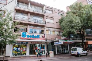 un edificio en una calle de la ciudad con una tienda en Apart Hotel Andino en Mendoza