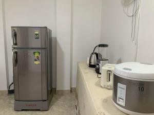 a kitchen with a refrigerator on a counter next to a appliance at Green Lodge in Weligama
